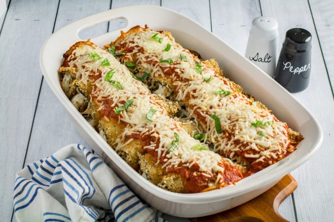 Savory oven-fried eggplant stuffed with an herby parmesan and ricotta cheese filling, smothered with marinara sauce and baked to perfection. This Easy Eggplant Rollatini is the perfect meal for when you just have to enjoy a hearty Italian dinner. A perfect match for your favorite bottle of vino, you won't believe how easy this dish is to make!