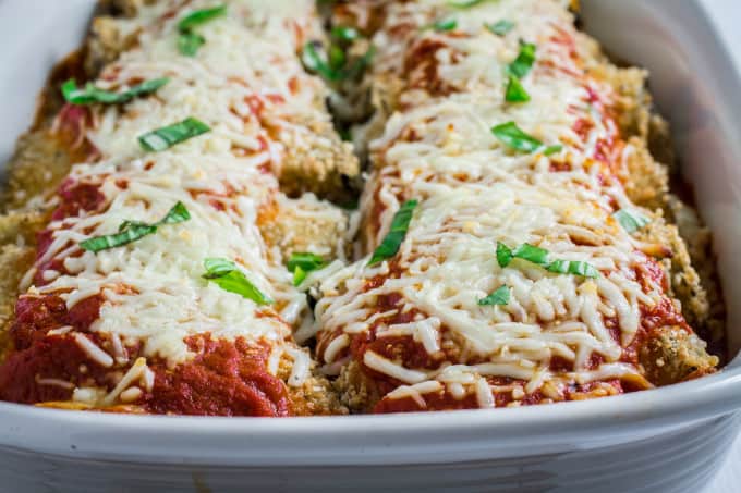 Savory oven-fried eggplant stuffed with an herby parmesan and ricotta cheese filling, smothered with marinara sauce and baked to perfection. This Easy Eggplant Rollatini is the perfect meal for when you just have to enjoy a hearty Italian dinner. A perfect match for your favorite bottle of vino, you won't believe how easy this dish is to make!