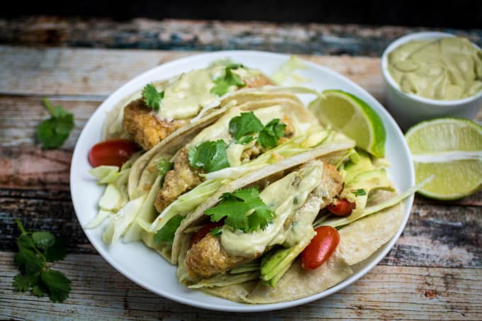 Crispy, juicy oven-fried fish smothered in a creamy, spicy avocado sauce and nestled in a warm tortilla. These Oven Fried Fish Tacos with Spicy Avocado Cream Sauce are simply perfect. Top with crunchy cabbage, cilantro, and a squeeze of fresh lime for an incredible flavor in this insanely easy-to-make dish!