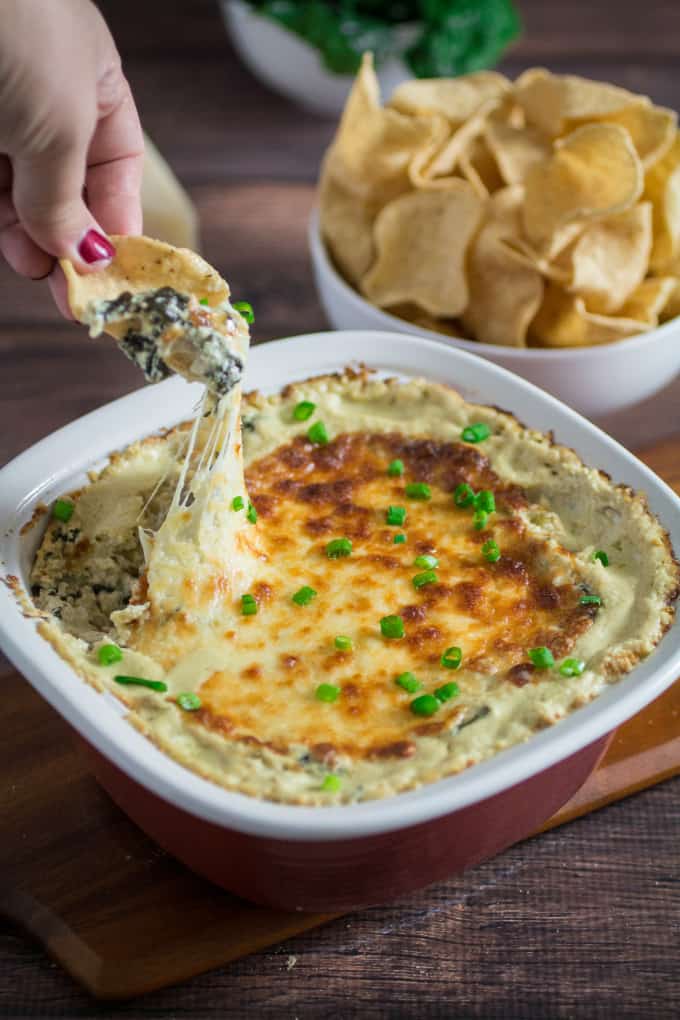 Cheesy, rich, and comfortingly creamy, it doesn't get much better than this classic Spinach Artichoke Dip. Topped with mozzarella cheese and baked to perfection, this dip recipe can be served with tortilla chips or a toasted baguette. You may want to make extra, this is one flavorful party food that won't last long once it's on the table! 