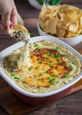 Cheesy, rich, and comfortingly creamy, it doesn't get much better than this classic Spinach Artichoke Dip. Topped with mozzarella cheese and baked to perfection, this dip recipe can be served with tortilla chips or a toasted baguette. You may want to make extra, this is one flavorful party food that won't last long once it's on the table!