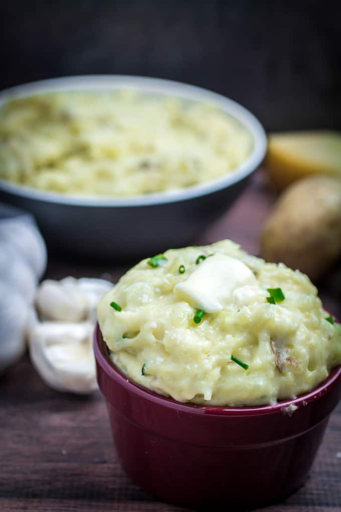 Creamy, buttery Yukon gold potatoes are mashed together with garlic and sharp Parmesan cheese in these Creamy Garlic Parmesan Mashed Potatoes. These potatoes are perfect for your Thanksgiving table, but so easy that you'll want to make them all year round. Top with chives and serve with an extra sprinkle of Parmesan cheese and butter for the perfect holiday side dish.