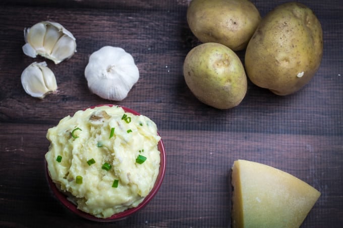 Creamy, buttery Yukon gold potatoes are mashed together with garlic and sharp Parmesan cheese in these Creamy Garlic Parmesan Mashed Potatoes. These potatoes are perfect for your Thanksgiving table, but so easy that you'll want to make them all year round. Top with chives and serve with an extra sprinkle of Parmesan cheese and butter for the perfect holiday side dish.