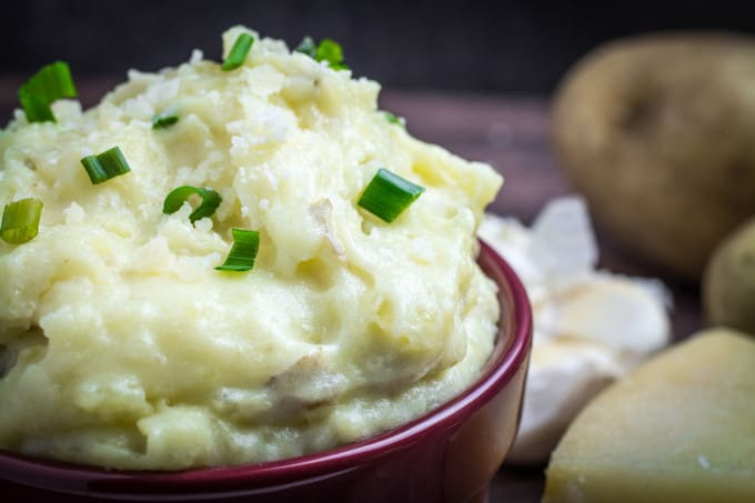 Creamy, buttery Yukon gold potatoes are mashed together with garlic and sharp Parmesan cheese in these Creamy Garlic Parmesan Mashed Potatoes. These potatoes are perfect for your Thanksgiving table, but so easy that you'll want to make them all year round. Top with chives and serve with an extra sprinkle of Parmesan cheese and butter for the perfect holiday side dish.