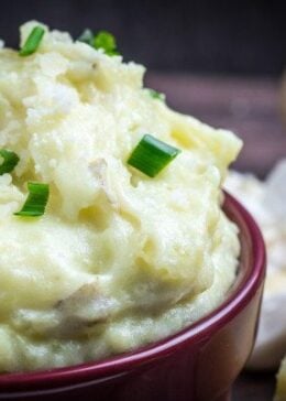 Creamy, buttery Yukon gold potatoes are mashed together with garlic and sharp Parmesan cheese in these Creamy Garlic Parmesan Mashed Potatoes. These potatoes are perfect for your Thanksgiving table, but so easy that you'll want to make them all year round. Top with chives and serve with an extra sprinkle of Parmesan cheese and butter for the perfect holiday side dish.