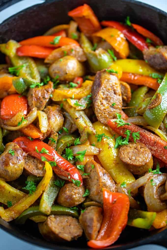 A closeup of a skillet of fully cooked sausage, peppers, and onions. 
