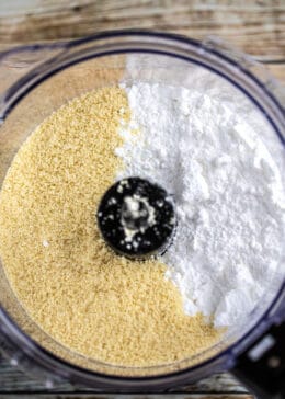 downward view of powdered sugar and almond flour in a food processor