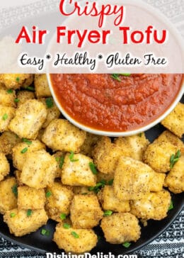 Pinterest pin with title box on top. Overhead photo of air fried golden brown tofu cubes on a plate next to a bowl of marinara dipping sauce.