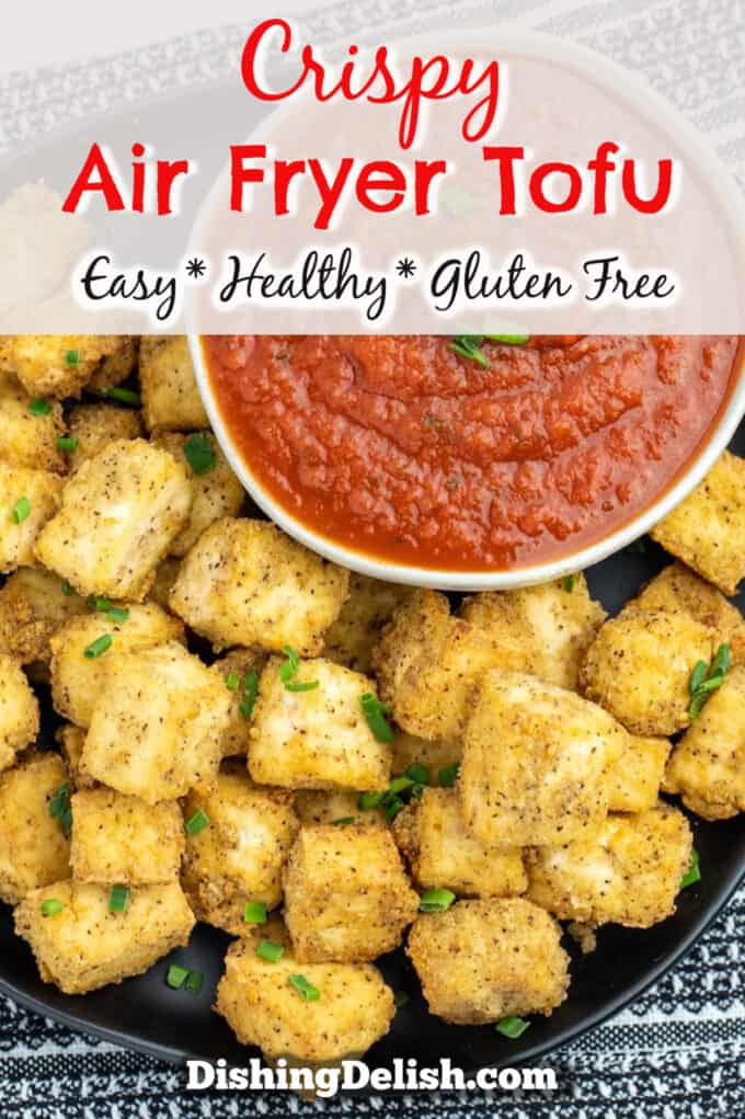Pinterest pin with title box on top. Overhead photo of air fried golden brown tofu cubes on a plate next to a bowl of marinara dipping sauce.