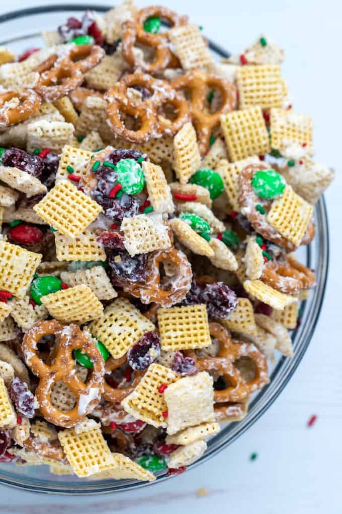 downward view of bowl with christmas chex mix made of pretzels, chex cereal, M&Ms, and dried cranberries coated in white chocolate