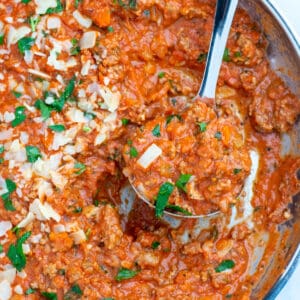 Turkey bolognese in a skillet with a spoon scooping sauce