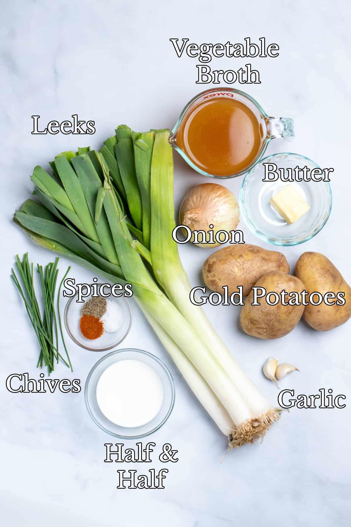 Ingredients on a white counter top for potato leek soup.