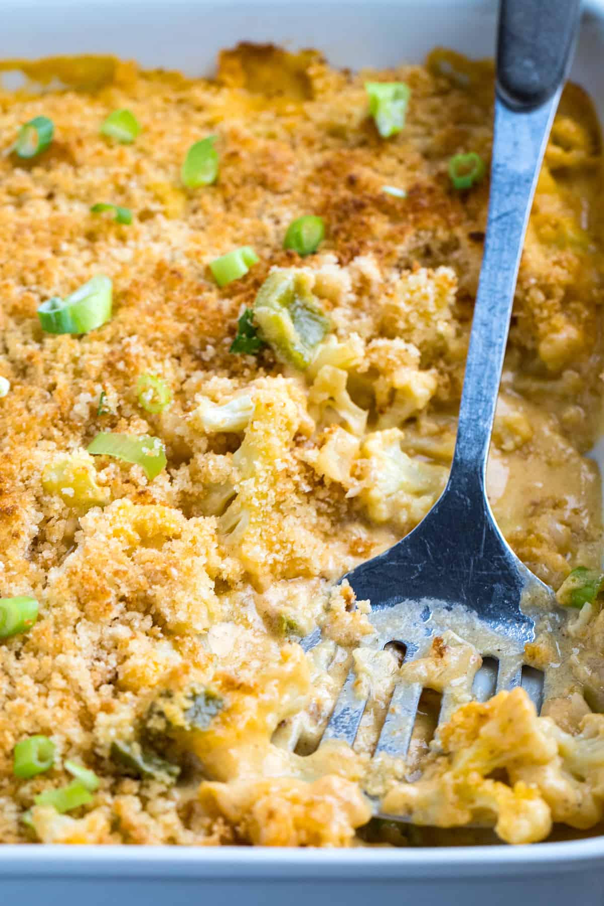 Cauliflower Au Gratin in a baking dish with a spatula.