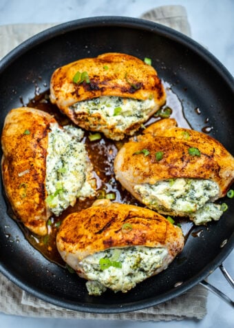 Finished broccoli and cheese stuffed chicken breasts in a nonstick skillet.