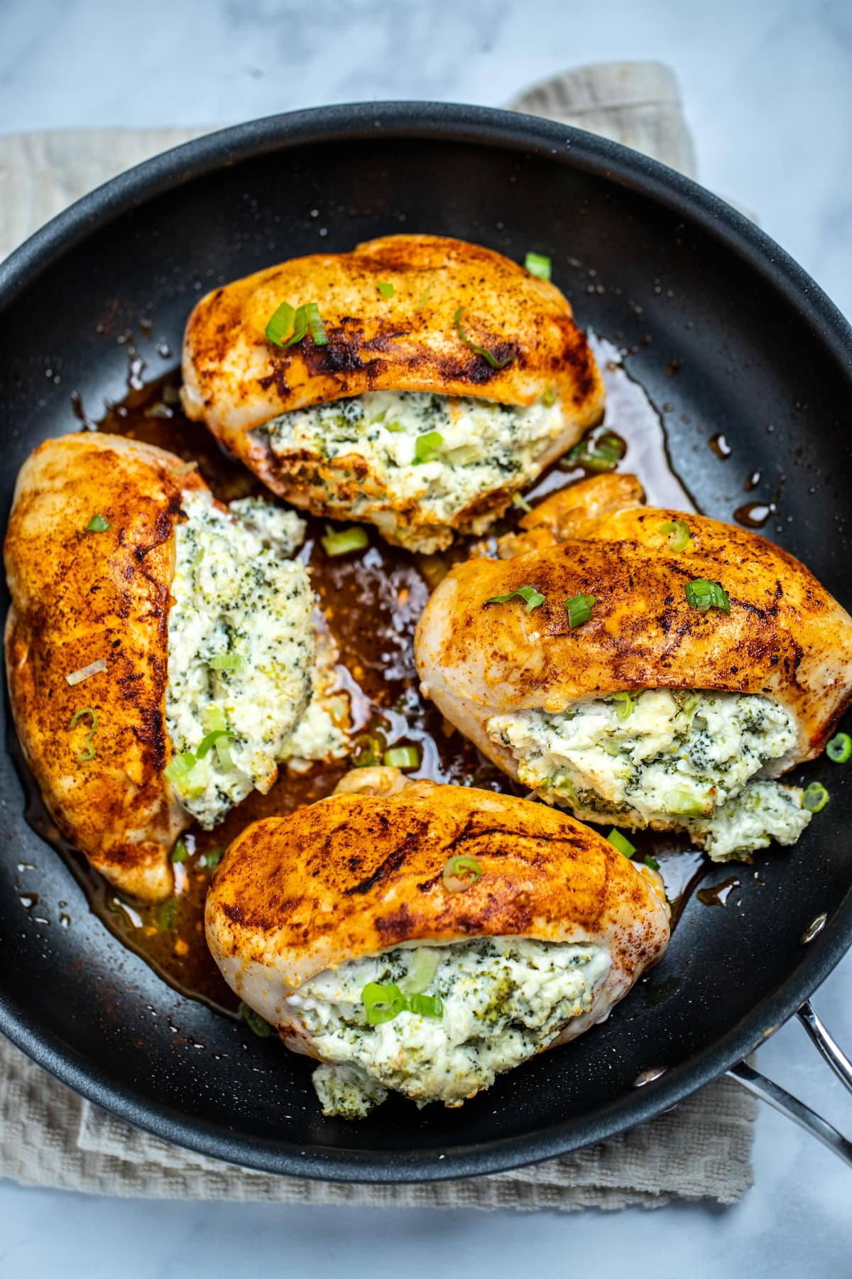 Finished broccoli and cheese stuffed chicken breasts in a nonstick skillet.