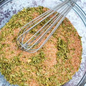 Rotisserie Chicken Seasoning in a bowl stirred by a whisk.