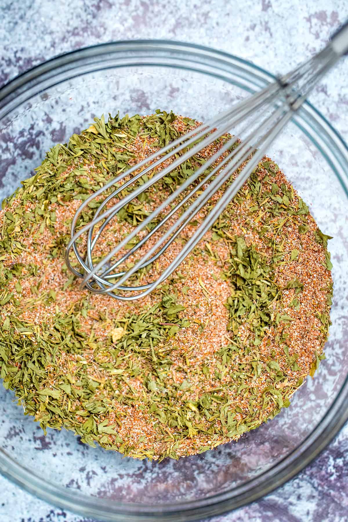 Rotisserie Chicken Seasoning in a bowl stirred by a whisk.