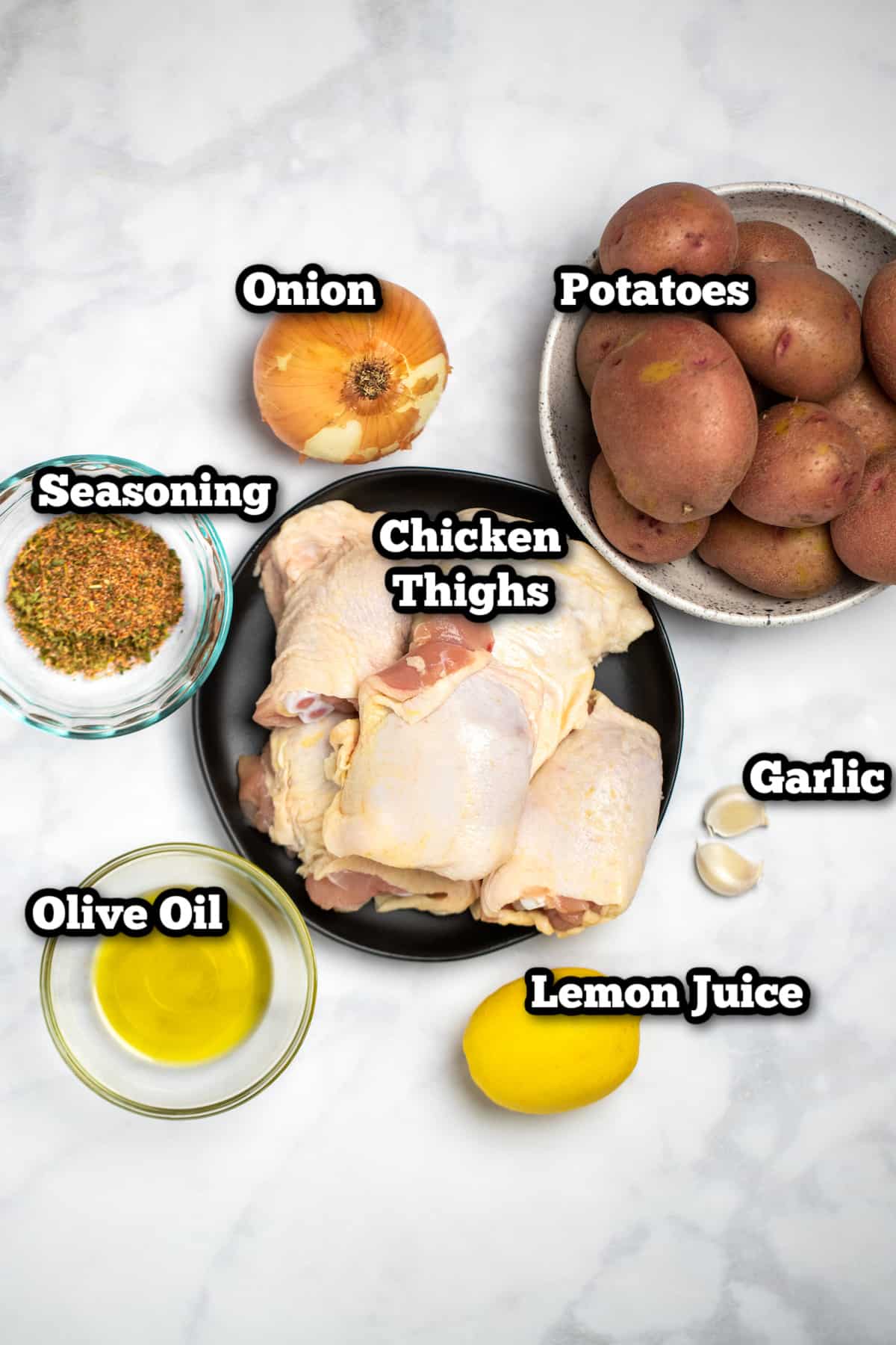 Ingredients for slow cooker chicken and potatoes sitting on a marble table.