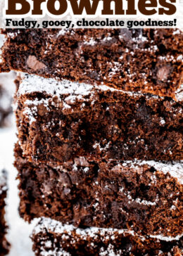 Pinterest pin with a photo of four brownies stacked on top of each other dusted in powdered sugar.