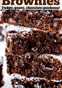 Pinterest pin with a photo of four brownies stacked on top of each other dusted in powdered sugar.