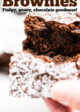 Pinterest pin with a photo of two hands breaking a brownie in half.