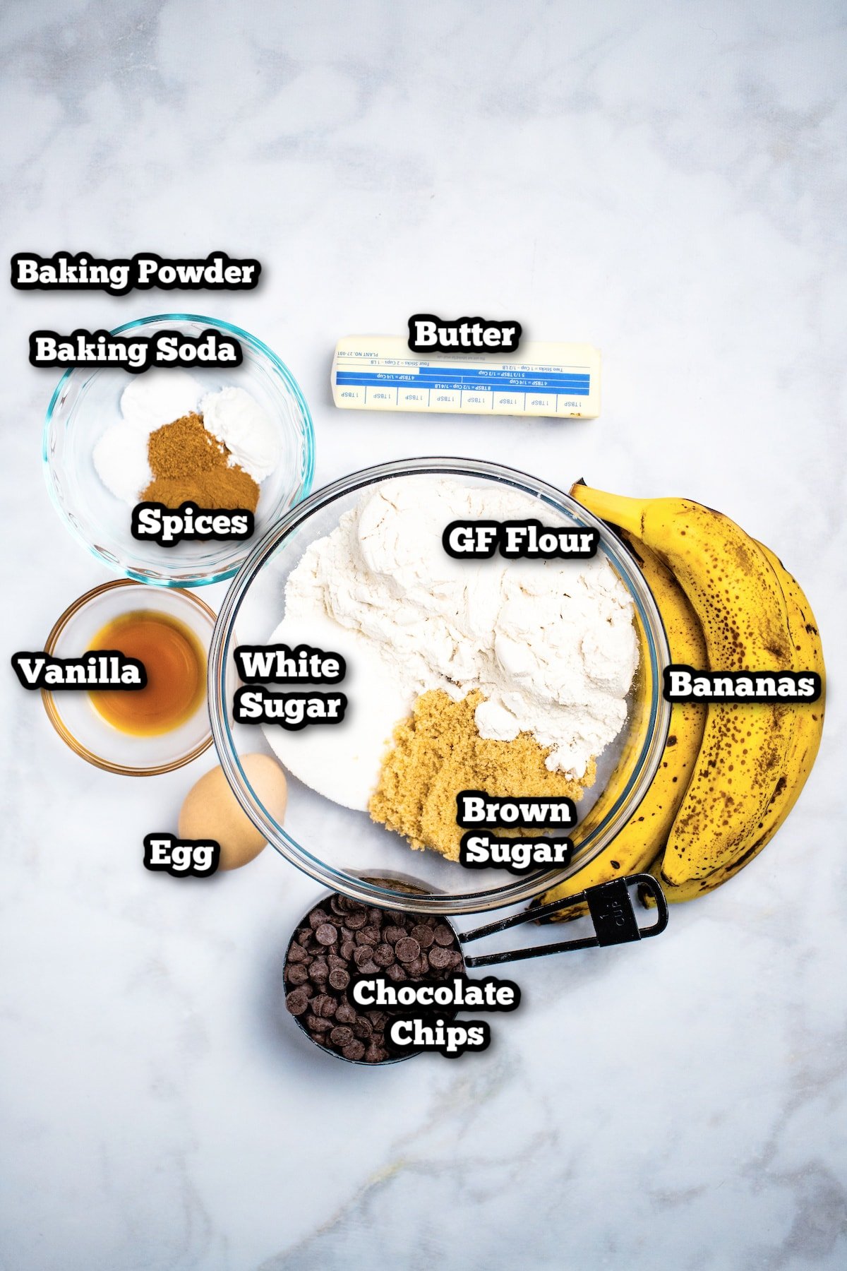 Individual ingredients for chocolate chip banana muffins sitting on a table.