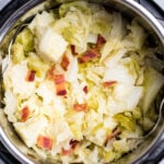 An instant pot full of cooked buttered cabbage topped with crispy bacon pieces.