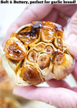 Pinterest pin with a hand holding a roasted garlic bulb.