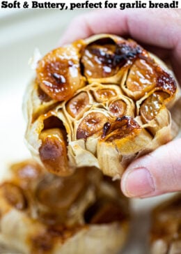 Pinterest pin with a photo of a hand holding a roasted garlic bulb.