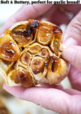 Pinterest pin with a hand holding a roasted garlic bulb.