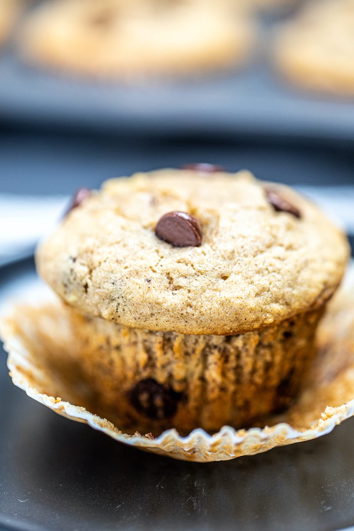 A banana muffin sitting in a muffin wrapper on a table.