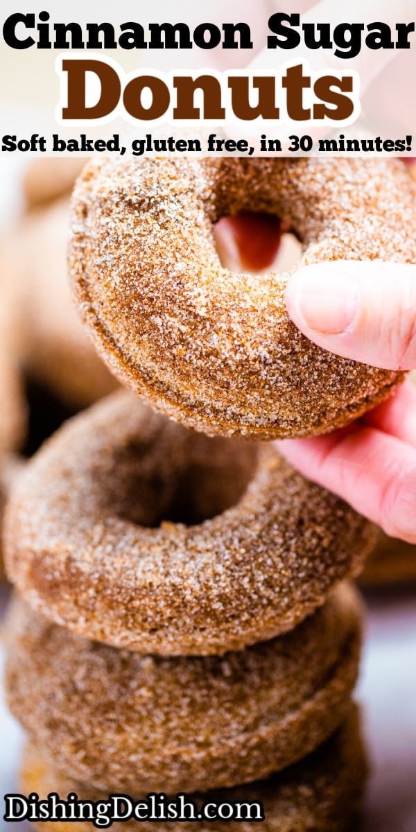 Pinterest pin with four doughnuts coated in cinnamon sugar stacked on top of each other and two hands holding the top doughnut.