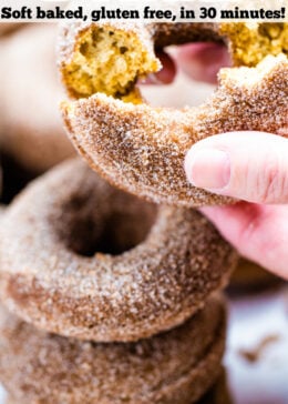 Pinterest pin with four doughnuts coated in cinnamon sugar stacked on top of each other and two hands holding the top doughnut.