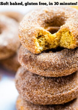 Pinterest pin with four doughnuts coated in cinnamon sugar stacked on top of each other and two hands holding the top doughnut.