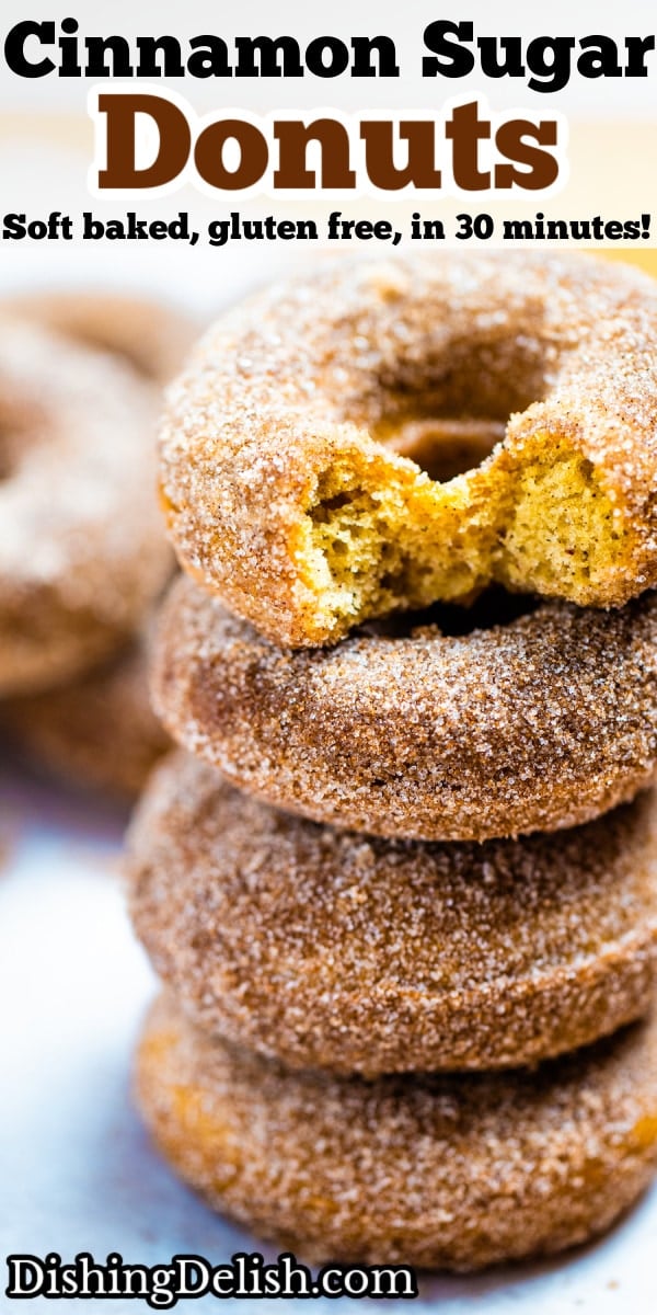 Pinterest pin with four doughnuts coated in cinnamon sugar stacked on top of each other and two hands holding the top doughnut.