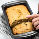 Pinterest pin with a loaf of banana bread in a bread pan on a table.