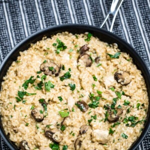 A skillet full of gluten free mushroom chicken risotto on a table.