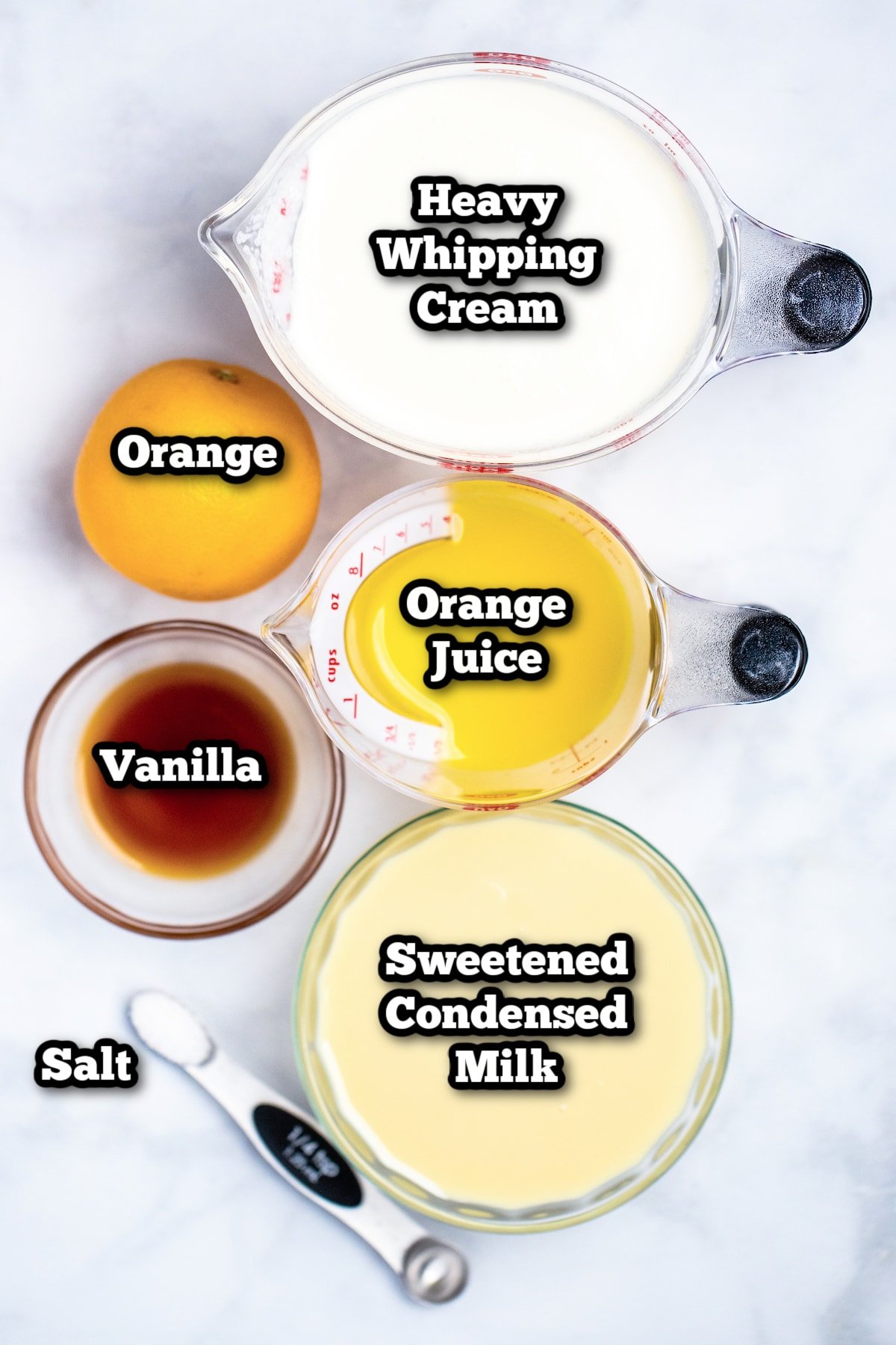 Individual ingredients needed to make orange ice cream on a table.