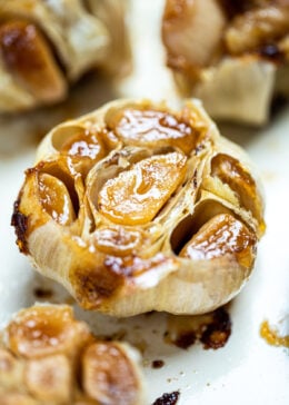 Roasted garlic bulbs sitting in a baking dish.