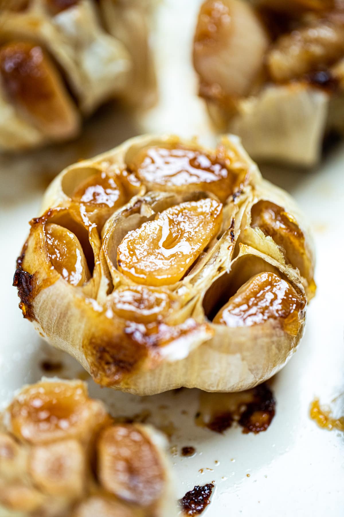 Roasted garlic bulbs sitting in a baking dish.