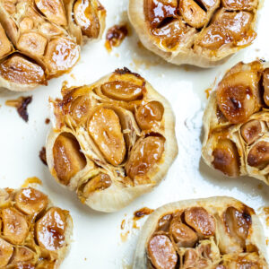 Roasted garlic bulbs sitting in a baking dish.