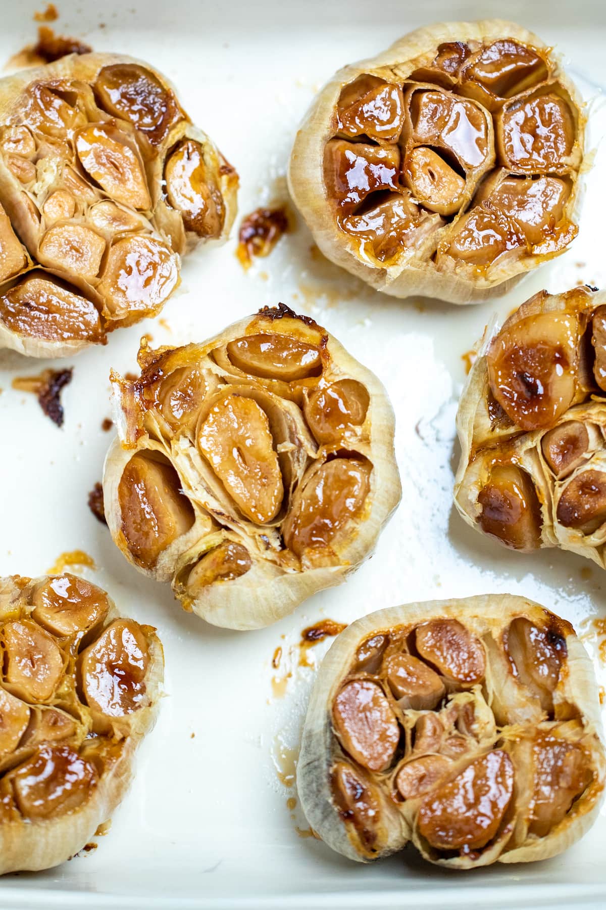 Roasted garlic bulbs sitting in a baking dish.