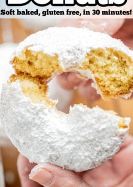 Pinterest pin with a hand breaking a powdered sugar donut in half.