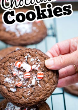 A pinterest pin of a hand holding a peppermint chocolate cookie over other cookies on a cooling rack.