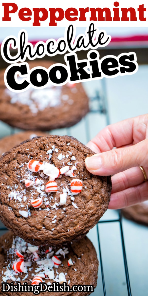 A pinterest pin of a hand holding a peppermint chocolate cookie over other cookies on a cooling rack.