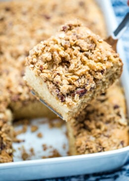 A spatula holding a piece of gluten free coffee cake above the baking dish.