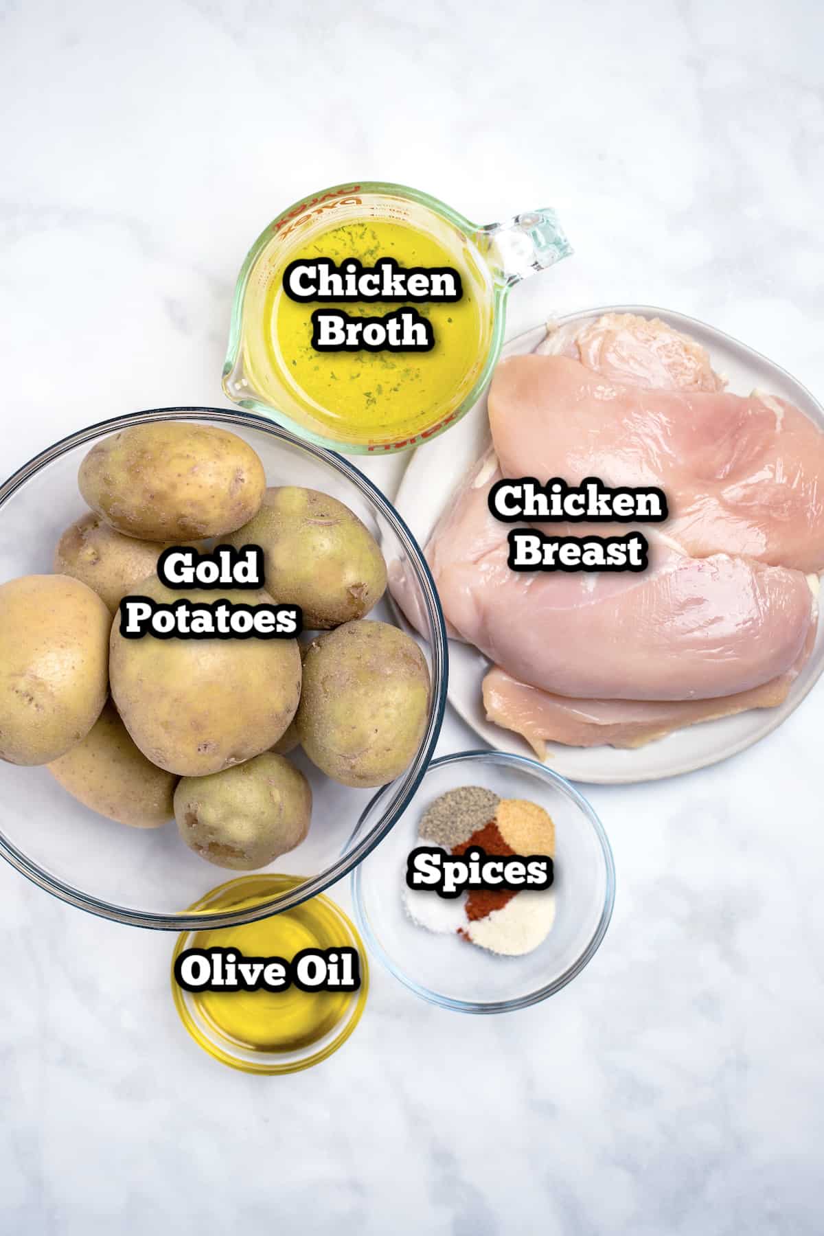 Individual ingredients for chicken and potatoes on a table.