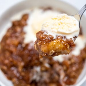Pinterest pin with a bowl of apple crisp and a spoonful topped with vanilla ice cream.