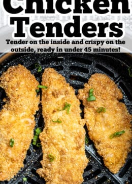 Pinterest pin with three air fryer chicken tender pieces sitting in the air fryer basket topped with green onions.