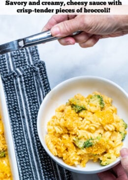 Pinterest pin of a hand serving broccoli mac and cheese into a bowl.